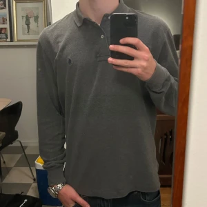 Polo ralph lauren långärmad piké  - Säljer nu denna gråa ralph lauren långärmade pikén. Den är i nyskick bara använd ett fåtal gånger. Nypris 1500kr