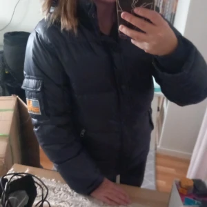Svea dunjacka  - Varm dunjacka från märket Svea avtagbar luva den passar även s också lite skavanker en knapp som är svår knäppt men annars i bra skicka 