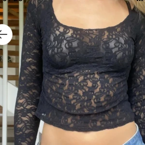 Svart spetsblus - Snygg svart spetsblus med långärmad design. Perfekt för en utekväll eller fest. Den har en tight passform och är tillverkad i ett genomskinligt spetsmaterial som ger en elegant look. Passar bra till både jeans och kjol. Bild från förra säljaren.