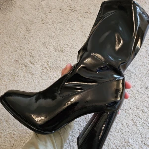 Even&Odd Svarta lackstövletter med klack - Snygga svarta stövletter från Even&Odd i lack med hög klack och spetsig tå. Perfekta för en utekväll eller fest. De har en glansig finish som verkligen sticker ut.