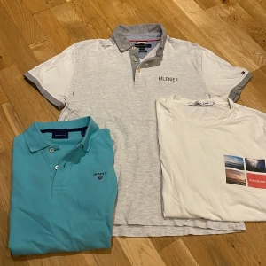 Tre stiliga t-shirts från GANT, Calvin Klein och Hilfiger - Säljer tre snygga t-shirts i bra skick. En ljusblå GANT piké med knappar, en vit Calvin Klein t-shirt med tryck och en grå Hilfiger piké. Passar till det mesta. Strl S. 120 för alla eller 50kr/st