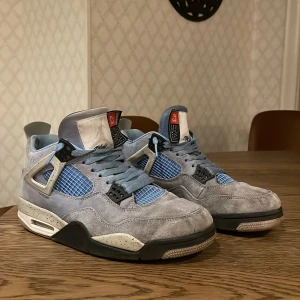 Nike Air Jordans i ljusblå mocka - Säljer ett par snygga Nike Air Jordans i ljusblå mocka. Skorna har en cool design med svarta och vita detaljer samt snörning. Perfekta för både vardag och fest! De är i bra skick med lite slitage på insidan.