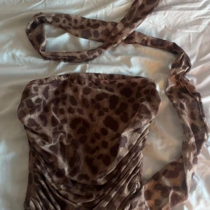 Leopardmönstrad oneshoulder topp - Snygg leopardmönstrad oneshoulder topp med knytband. Perfekt för en utekväll eller fest! Den har en tight passform och är supertrendig. Materialet känns mjukt och bekvämt mot huden.