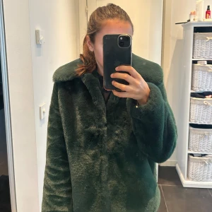 Grön pälsjacka - Säljer en supermjuk och fluffig grön pälsjacka i storlek S. Perfekt för att hålla sig varm och stilren under kyliga dagar. Jackan har en klassisk krage och långa ärmar, vilket gör den både bekväm och trendig. Passar perfekt för höst och vinter!