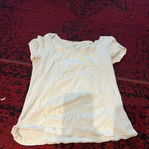 Vit kortärmad topp - Säljer en enkel och stilren vit topp med korta ärmar. Perfekt för vardagsbruk eller att styla upp med accessoarer. Toppen är i ett mjukt och bekvämt material, vilket gör den idealisk för sommarens varma dagar.
