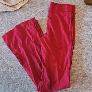 Röda byxor med utsvängda ben. - Snygga röda byxor med utsvängda ben och med en bekväm passform. Byxorna har en elastisk midja för extra komfort.