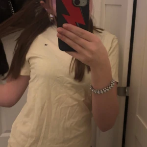 Gul t-shirt från Tommy Hilfiger - Säljer en gul t-shirt från Tommy Hilfiger med liten logga på bröstet. Perfekt för en avslappnad stil.