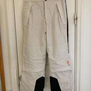 Vita Peak Performance sidbyxor slalom snowboard Peak  - Vita skidbyxor för slalom eller snowboard. Utmärkt skick i märket Peak Performance. Finns en minimal fläck på baksidan, men inget man lägger märke till. I övrigt utan några skavanker eller missfärgningar.