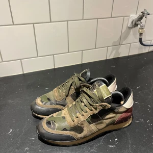 Valentino rockrunners  - Valentino rockrunners i storlek 42 men passar lite större. Kamouflage färgade med äkthetskvitto från Vestiaire. Se sista bilden för den lilla flawn, går att limma ihop snabbt. Säljes pågrund av att jag använder dem knappt. I bra skick!