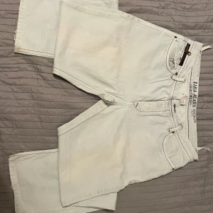 Ljusblå jeans från Zara - Snygga ljusblå jeans från Zara med dragkedja och knapp framtill. Klassisk femficksdesign med dekorativa sömmar på bakfickorna. Perfekta för en avslappnad stil. 