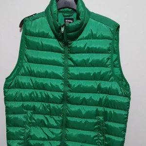 Grön dunväst från Sinsay - Snygg grön dunväst från Sinsay med dragkedja framtill. Perfekt för att hålla värmen under kyliga dagar. Västen har en quiltad design och är lätt att matcha med olika outfits.