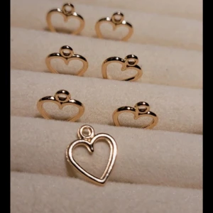 Guldiga hjärtformade berlocker  - Säljer ett set med guldiga hjärtformade berlocker. 