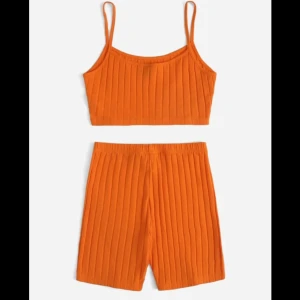 Orange ribbad linnetopp - Säljer en snygg orange ribbad linnetopp med smala axelband. Perfekt för varma dagar och ger en trendig look. Matcha med shorts eller kjol för en komplett outfit.