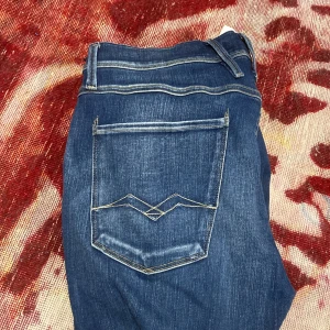 Blå jeansbyxor från Replay - Snygga blå jeansbyxor från Replay Anbass med en klassisk femficksdesign. De har en dragkedja och knapp framtill samt stilrena sömmar på bakfickorna. Perfekta för en avslappnad look.