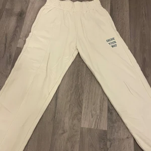 Beige mjukisbyxor med tryck - Säljer ett par bekväma beige mjukisbyxor med texten 'SHINE YOUR WAY' tryckt på ena benet. Byxorna har en elastisk midja, perfekta för en avslappnad stil.
