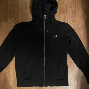Fred Perry Zip Hoodie - Säljer en stilren svart zip hoodie från Fred Perry i storlek L, true to size! Nypris: 1200kr! Skicket på tröjan är bra och är utan fläckar eller defekter🔥hör av dig vid funderingar/Karl!