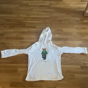 Hodded T-shirt Ralph lauren - En väldigt fin Ralph lauren tröja som är i ett bra skick skulle säga 8/10. Den har ett pyttelitet lagat hål vid magen( bild 4) men syns ingenting. Hör av er vid minsta fråga.