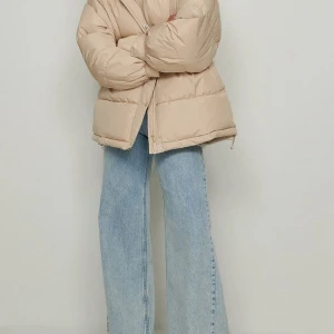 Beige dunjacka - Säljer en snygg beige dunjacka med dragkedja. Jackan har en pufferdesign som ger en skön och varm känsla. Perfekt för kyliga dagar och har en stilren look som passar till det mesta. 🧥