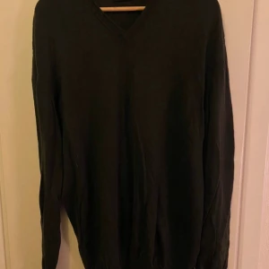 Mörkgrön tröja från Clipper - Säljer en stilren mörkgrön tröja från Clipper. Tröjan har en v-ringad design och långa ärmar, perfekt för kyligare dagar. Den är tillverkad i ett mjukt material som ger en bekväm passform. Passar bra till både jeans och chinos.