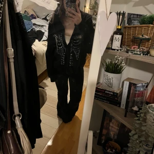 Svart hoodie med strassdetaljer - Säljer en svart hoodie med dragkedja och coola strassdetaljer i form av ett skelettmönster på framsidan. Perfekt för en edgy look! Skriv vid frågor💗