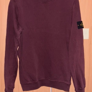 Röd tröja från Stone Island - Säljer en röd tröja från Stone Island med deras ikoniska märke på ärmen. Tröjan har en rund hals och långa ärmar, perfekt för en stilren look. Passar bra till både jeans och chinos. Perfekt för höst och vinter och självfallet äkta. Går att hitta på deras hemsida. Skriv om frågor🌹🙏 nypris:2999