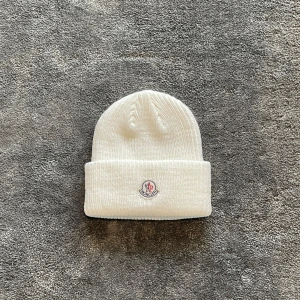 Moncler Mössa - En vit Moncler mössa perfekt nu inför hösten, den är helt ny och aldrig använd. Kontakta mig för yttligare frågor eller om fler bilder önskas! 🦹‍♂️