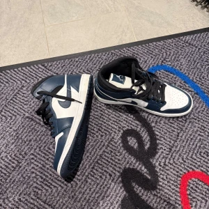 Nike air Jordan mid i grön och vitt - Snygga Nike sneakers i en stilren kombination av blått och vitt. Skorna har en klassisk design med snörning och en bekväm passform. Perfekta för både vardag och sportiga aktiviteter. Knappt använda 