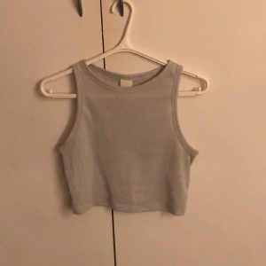 Grå glittrig linnetopp - Säljer en snygg grå glittrig linnetopp. Perfekt för att lägga till lite glitter i din outfit. Toppen är ärmlös och croppad, vilket gör den idealisk för varmare dagar. Glittret finns ganska diskret i toppen men syns mer i blixt som ni kanske ser i 3 och 4 bilden. Toppen funkar både till vardags men även till fest!!😍😍