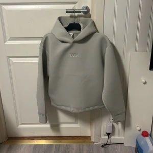 Grå hoodie från bherska - Säljer en stilren grå hoodie från bherska. Tröjan har en enkel design med en Paris text på bröstet. Perfekt för en avslappnad look. Hoodie är limiterad på bherska och den finns inte kvar längre utan den blev slutsåld