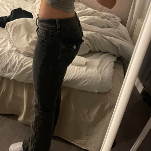 Grå-svarta bootcut jeans - Ett par grå-svarta jeans som är bootcut och low-waist, är storlek 164 men passar xs och s, inga defekter och är inte använda så mycket. Perfekta till skolstarten🩷