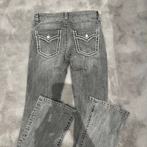 Gråa Jeans med fickor - Skitsnygga jeans som är i storlek 170 men skulle säga att de passar en S. De har true religion likande tryck på fickorna som är as ballt