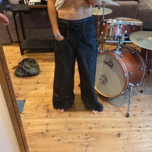 Svarta jeans med Hello Kitty-brodyr - Säljer ett par svarta, självsydda jeans från By Eneroth med en cool Hello Kitty-brodyr på bakfickan. De har en loose passform i klassisk JNCO stil. Stora fickor så man får plats med Cola. Saknar Knapp och lätt slitage men inget som benim inte kan lösa 🔫 Storlek 30 i midjan.