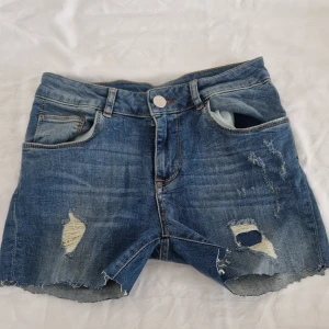 Blå jeansshorts - Säljer ett par coola blå jeansshorts med slitninga på framsidan. Passar För Xs/S. Gamla shorts från lager 157 som säljs inte längre! Köparen står för frakten. Läs min bio om du skulle vilka köpa // Priset kan diskuteras