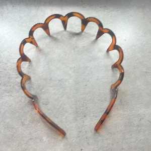 Ett diadem  - Ett brunt diadem med svart mönster. Bra skick, knappt användt.