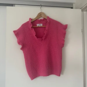 Mörkrosa väst i jättebra skick - En mörkrosa väst i jättebra skick, endast använd några fåtal gånger. Storlek står dessvärre inte, men skulle säga att det är en M. 
