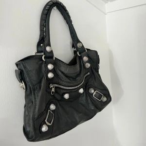 Balenciaga väska - Intressekoll på min gråa ÄKTA balenciaga väska som jag köpt begangnat! Den är i gott men använt skick därav priset jag säljer den för. Den behövs garanterat lämnas in och smörjas då lädret börjar torka ut.