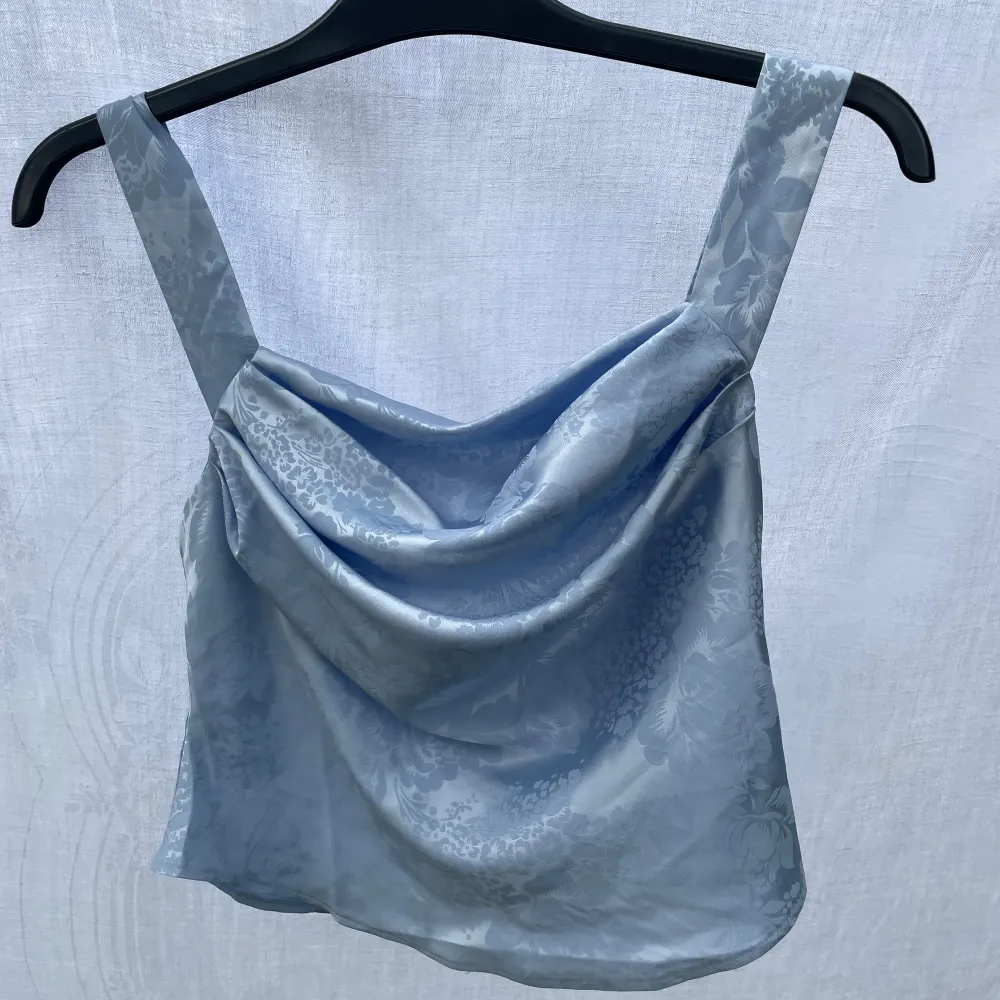 Fin blå topp i glansigt material, från asos, storlek 36 men liten i storleken. Nyskick, då den var för liten för mig.. Yläosat.