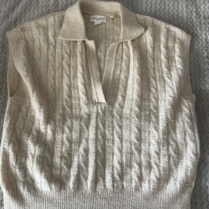 Beige stickad väst från Holly & Whyte - Säljer en beige stickad väst från Holly & Whyte by Lindex. Den har ett kabelstickat mönster och en klassisk krage med v-ringning. Västen är i storlek S och är i nyskick. Kontakta mig om du har fler frågor 😊