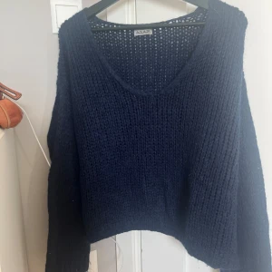 Mörkblå stickad tröja från Aylajk - Säljer en supermysig mörkblå stickad tröja från Aylajk. Den har en v-ringad hals och långa ärmar, perfekt för kyliga dagar. Perfekt för höst och vinter!