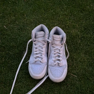 Vita Nike sneakers - Säljer ett par vita Nike sneakers i storlek herr 46. Skorna är inte jätte andvända och då i bra skick men fortfarande bekväma och snygga, det finns lite cresses.  Skorna är perfekta för vardags andvänding. Pris går att diskutera vid snabb affär 