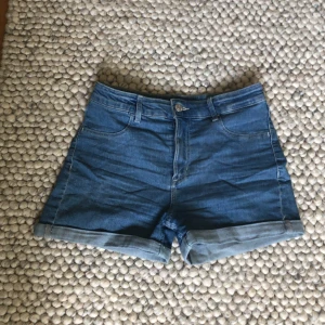 Blå jeansshorts från H&M - Säljer ett par snygga blå jeansshorts från H&M. De är i storlek 158 (dam S) och har en klassisk femficksdesign med upprullade benslut. Går också att rulla upp dom högre!☀️