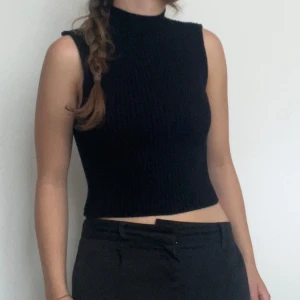 Svart ribbad ärmlös topp från Zara - Säljer en snygg svart ribbad topp från Zara. Den är ärmlös och har en tight passform som framhäver figuren. Perfekt för både vardag och fest! 🖤