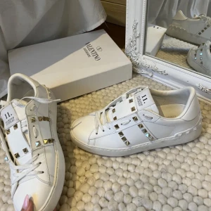 Vita sneakers från Valentino - Säljer ett par snygga vita sneakers från Valentino. De har coola guldfärgade nitar som ger en extra edge till looken. Skorna är i bra skick och passar perfekt till både vardag och fest. Storlek 39. Finns inga äktighetsbevis därav priset.🩷