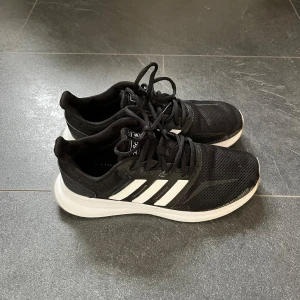 Adidas sneakers stl 39 1/3 - Svarta Adidas sneakers i fint skick, sparsamt använda. Kommer från djur- och rökfritt hem.