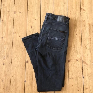 Nudie Jeans - Mörkgråa/mörkblåa nudie jeans perfekta inför hösten, sälj pga inte används! Skicket är bra(8/10) möjligtvis lite slitningar som bidrar med en retro känsla… hör av dig vid intresse och frågor!