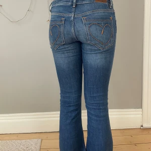 Lågmidjade jeans - Supersnygga lågmidjade bootcut jeans med broderade hjärtan på bakfickorna i fint skick💕⭐️