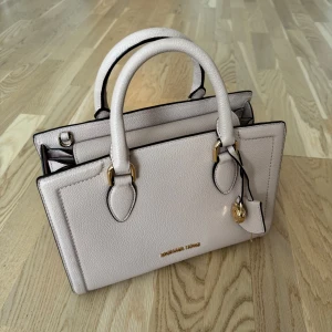Michael Kors Väska - Mindre väska i ljusrosa från märket Michael Kors  Mycket fint skick, endast använd fåtal gånger