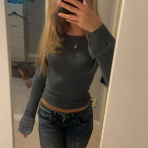 Långärmad tröja med slits  - Säljer en väldigt snygg blå långärmad tröja med slits i ärmarna, bra skick