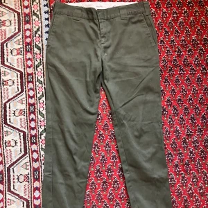 Gröna slim fit dickies, W32/L32 - Gröna dickies, mer gröna än vad framgår av bilden. Dem har en vit fläck och är lite noppriga på framsida. Annars fint skick. Det står att modellen är slimfit, men så länge man inte har Ulf Kristerssons vader så sitter de inte allt för tight. 
