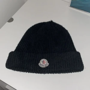 Moncler mössa  - Moncler mössa i svart färg som jag haft i nästan ett år, köpte förra hösten. Lite billigare pris eftersom det är ett litet håll på toppen. 